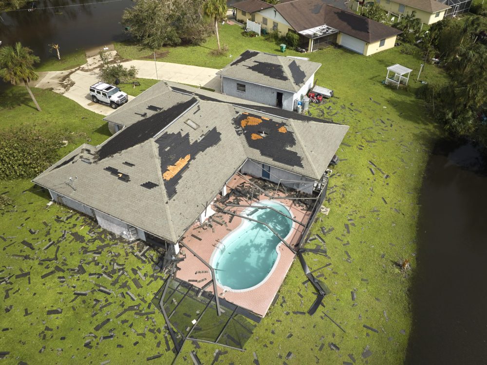 Hurricane Ian destroyed house roof in Florida residential area. Natural disaster and its consequences.